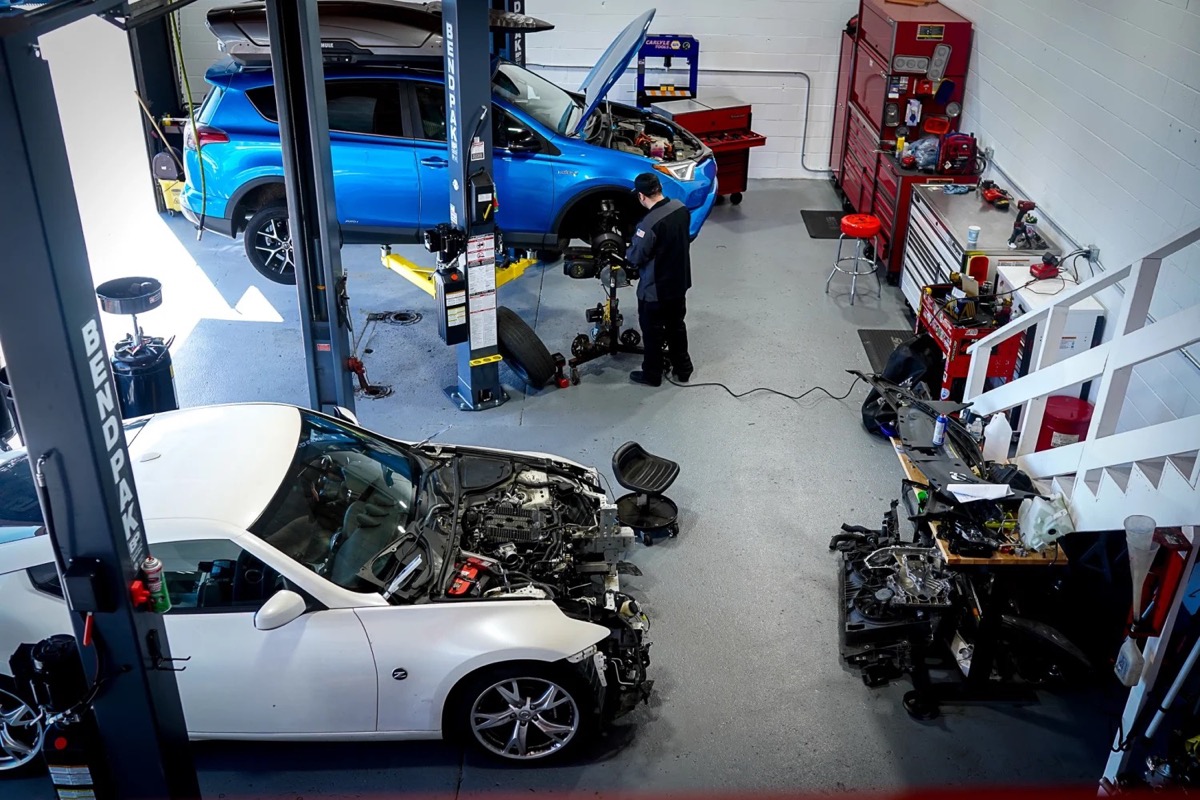 The whole shop from the stairs — a tech mid-job on a RAV4