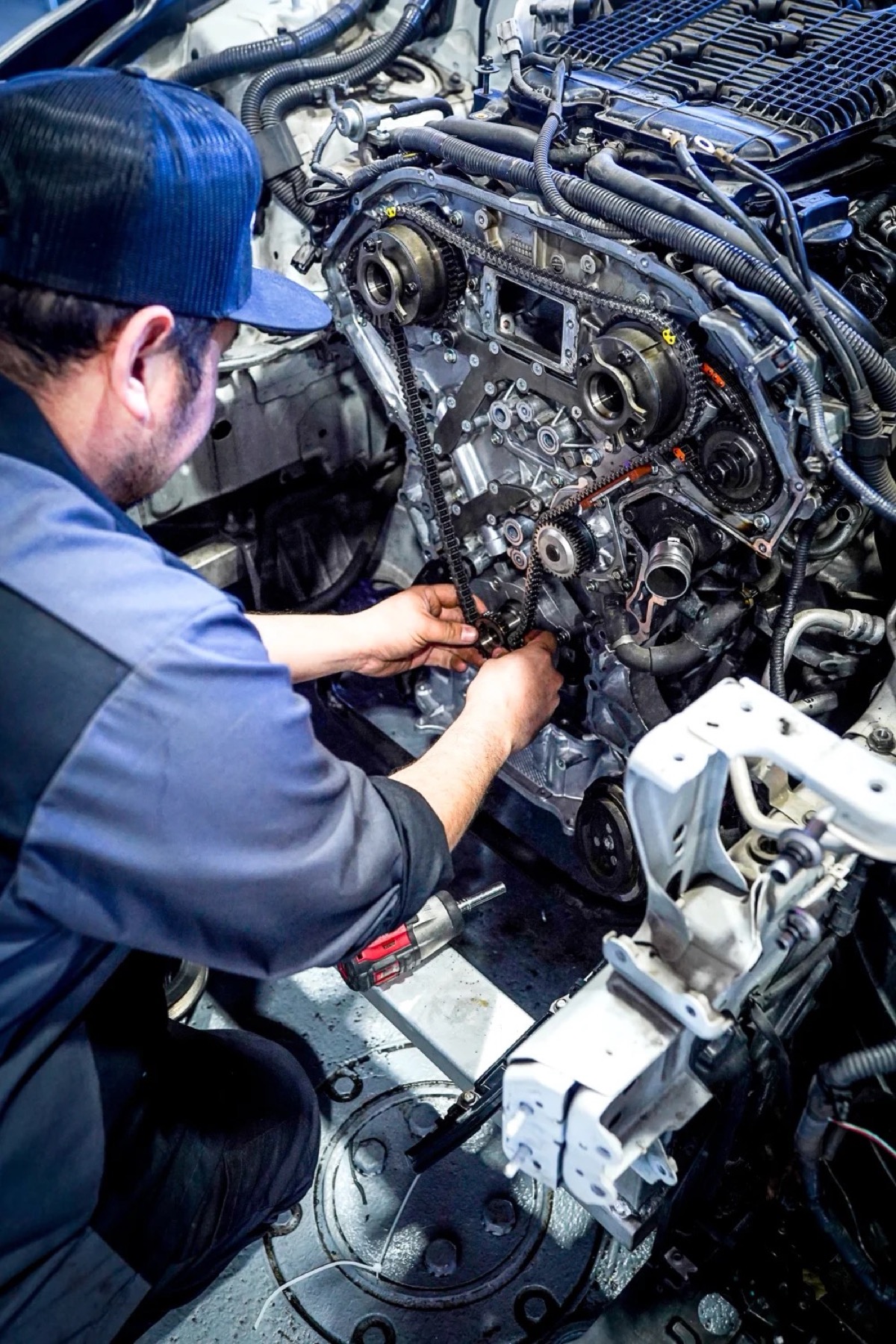 Hands in a timing-chain job — factory-level engine work