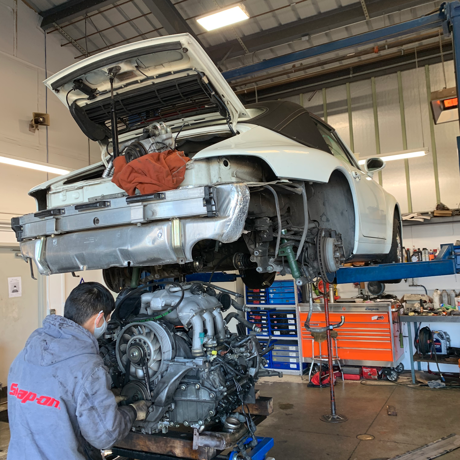 A Porsche 911 on the lift, engine out — the specialty work