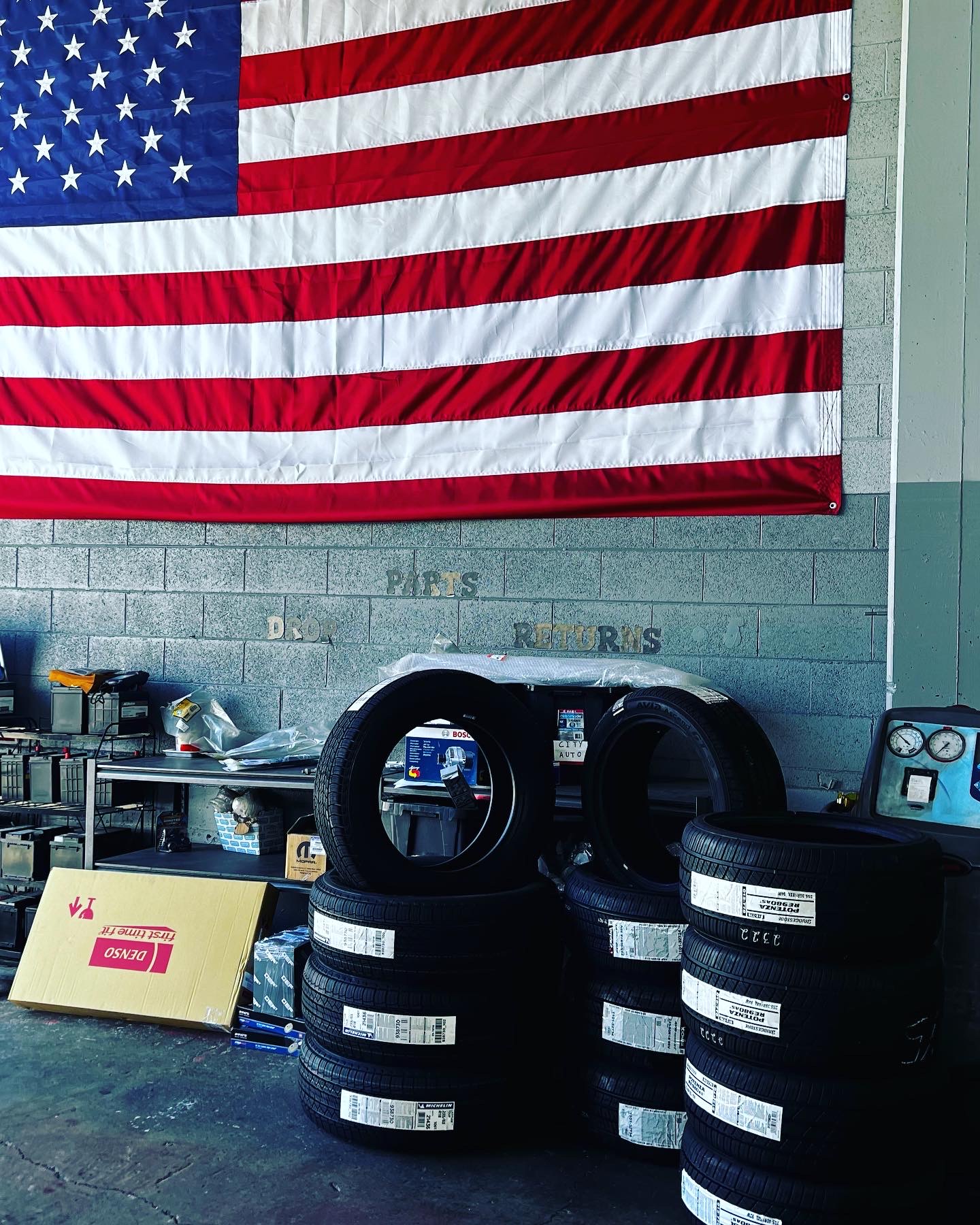 new tires stacked under the shop flag